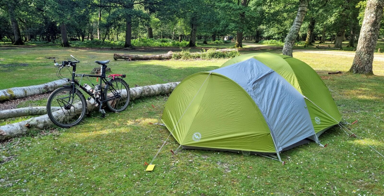 A tent and a bicycle in a park
