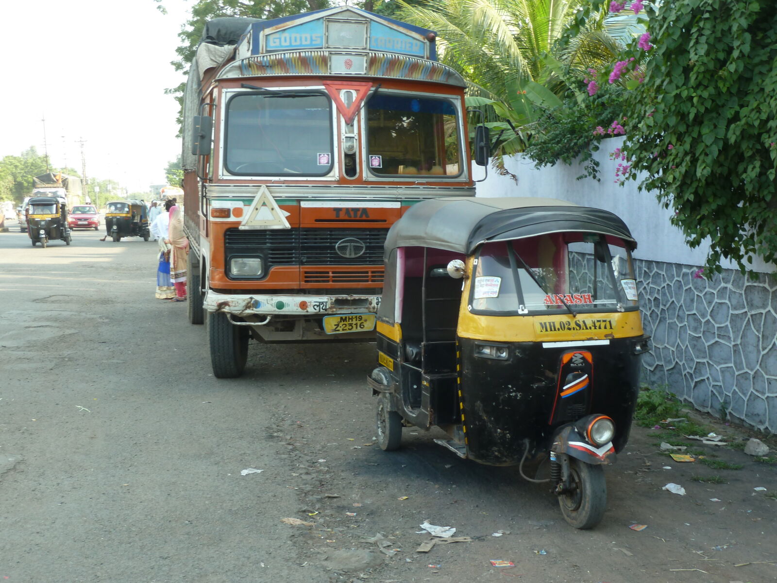 A rickshaw and a lorry parked on a street