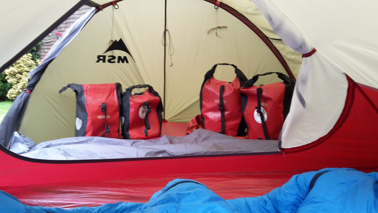A group of red bags in a tent