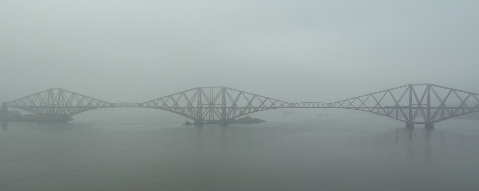 A bridge over water with fog